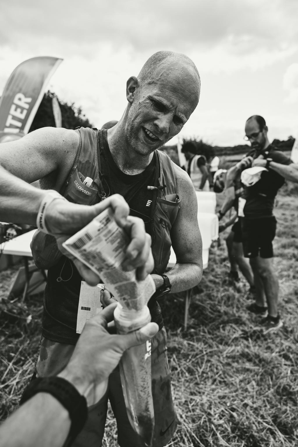 Helping to fill an ultra runners water bottle. Black and white photo