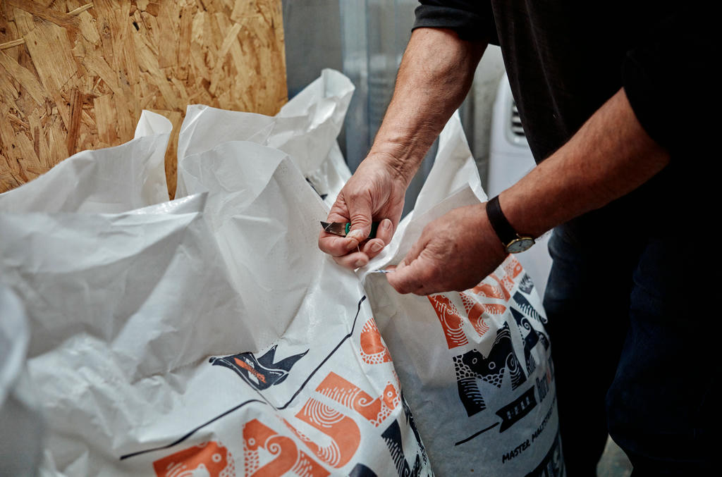 Keith opening a sack of grains at Dynamite Valley Brewing Co.