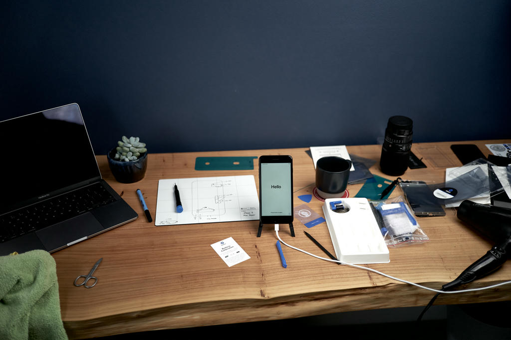 A messy workbench after changing the screen and battery on an iPhone 7 Plus